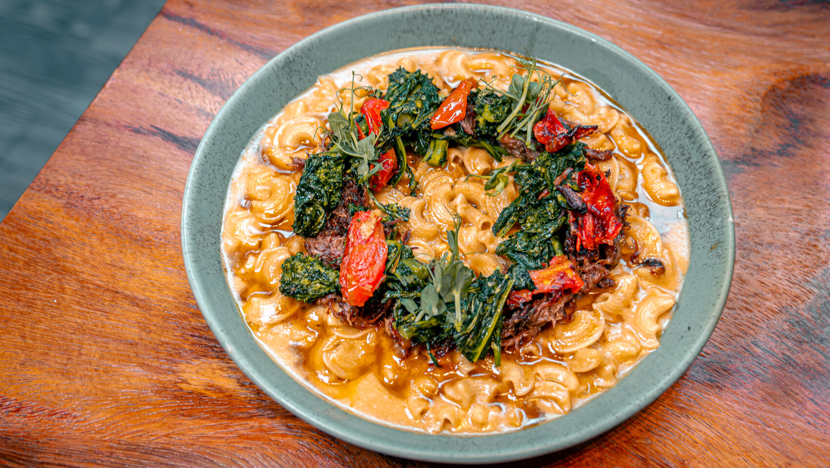 Pasta with braised meat, broccoli rabe, tomatoes, and fresh herbs.