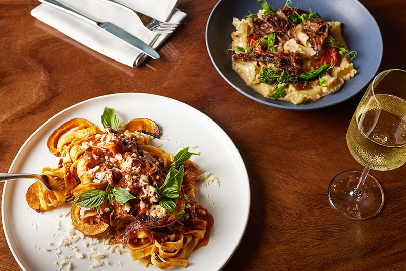 Entree options plated with a glass of wine at willowsong